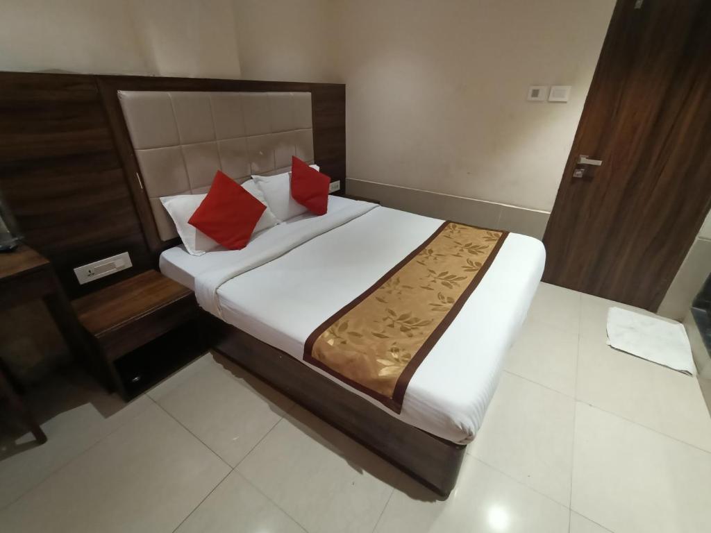 a bedroom with a bed with two red pillows at Hotel Regal Inn Andheri - Nearest Mumbai Airport T1 in Mumbai