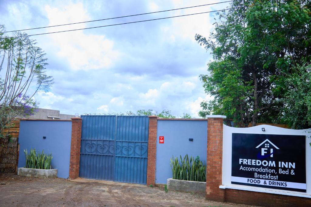 a building with two garage doors and a sign at freedom inn in Arusha