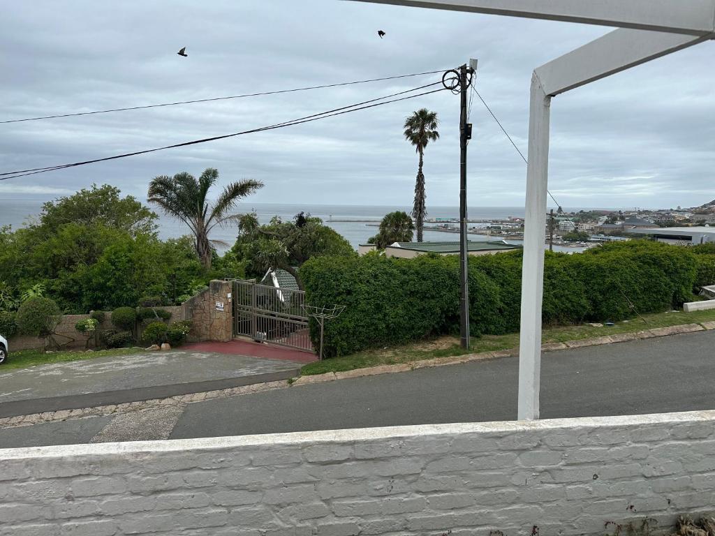 a view of a street with a house and the ocean at La Santos 2 in Mossel Bay