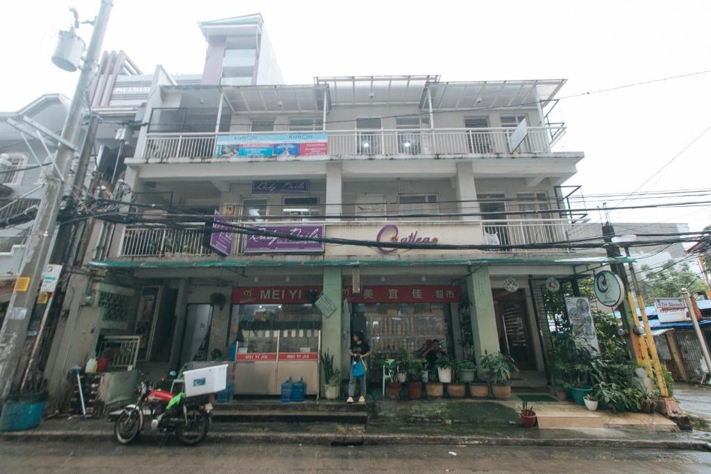 un edificio con una motocicleta estacionada frente a él en Catlea Inn, en Manila