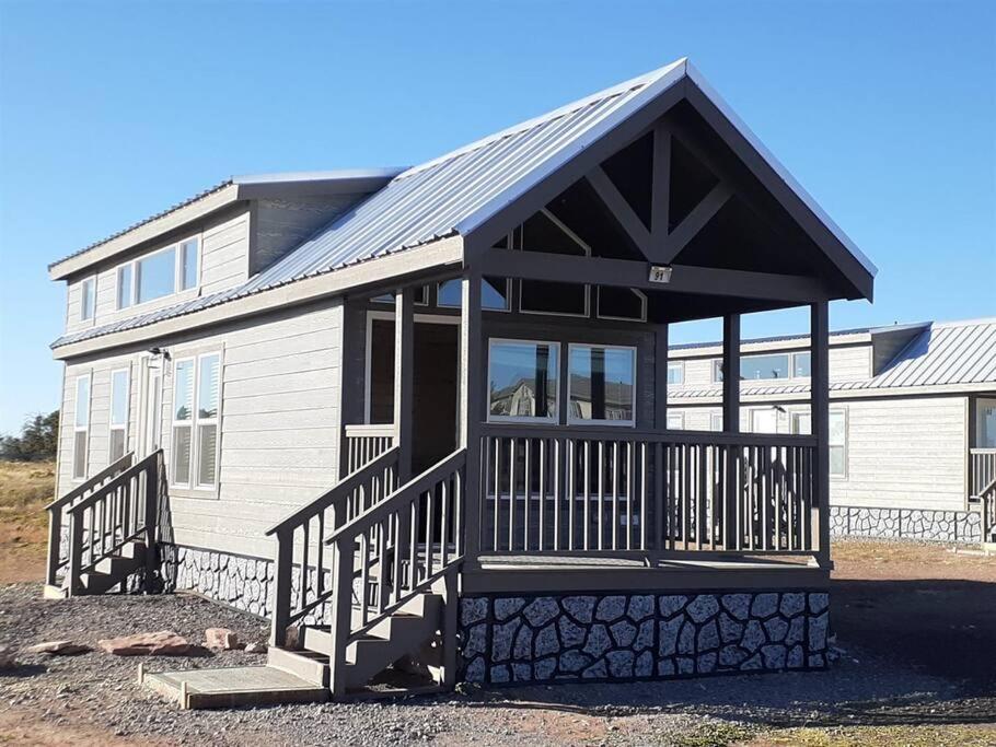 Cette petite maison dispose d'une terrasse couverte et d'un toit. dans l'établissement 092 Star Gazing Tiny Home near Grand Canyon South Rim Sleeps 8, à Valle