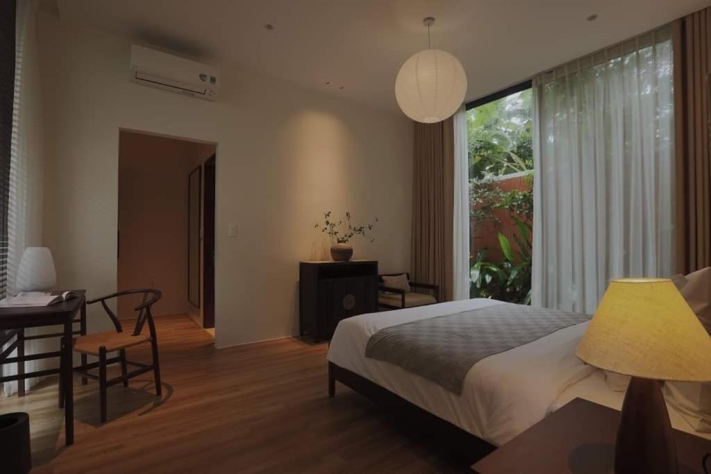 Schlafzimmer mit einem Bett, einem Schreibtisch und einem Fenster in der Unterkunft Nhãn Stay in Thôn Dương Xuân Hạ