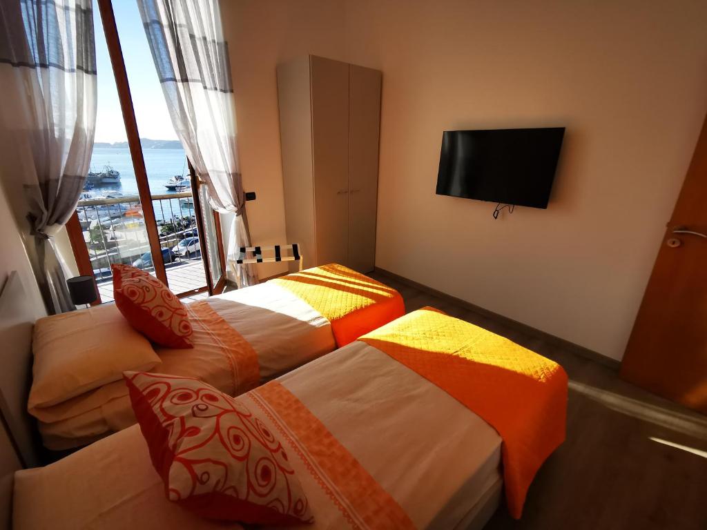 波佐利的住宿－Puteoli Sea View，配有电视的酒店客房内的两张床
