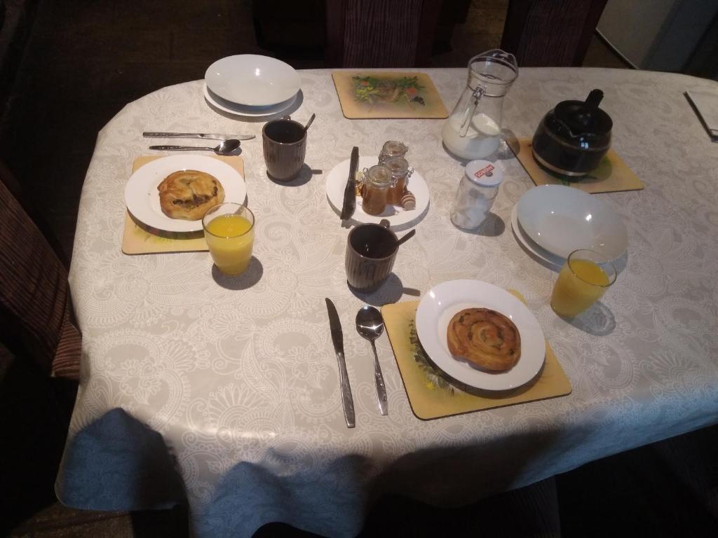ein weißer Tisch mit Teller mit Lebensmitteln drauf in der Unterkunft Chambre d&#39;hôtes de puy faucher in Arrènes