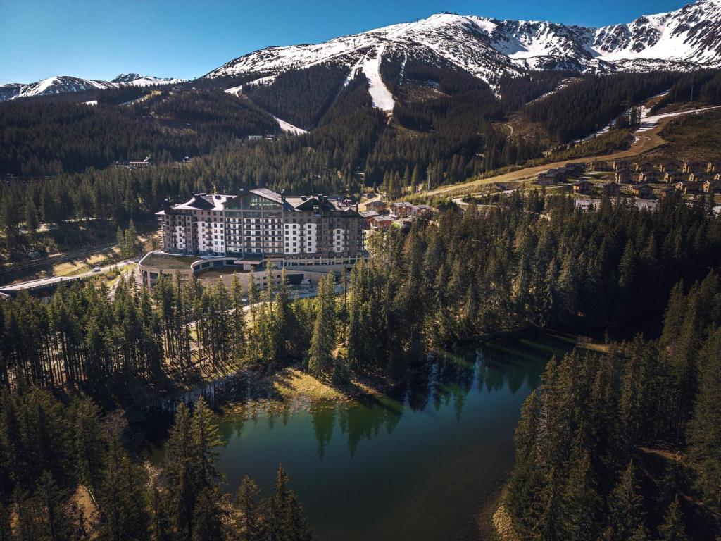 - une vue aérienne sur un complexe avec un lac et des montagnes dans l'établissement DAMIAN JASNA HOTEL RESORT and RESIDENCES, à Demänovská Dolina