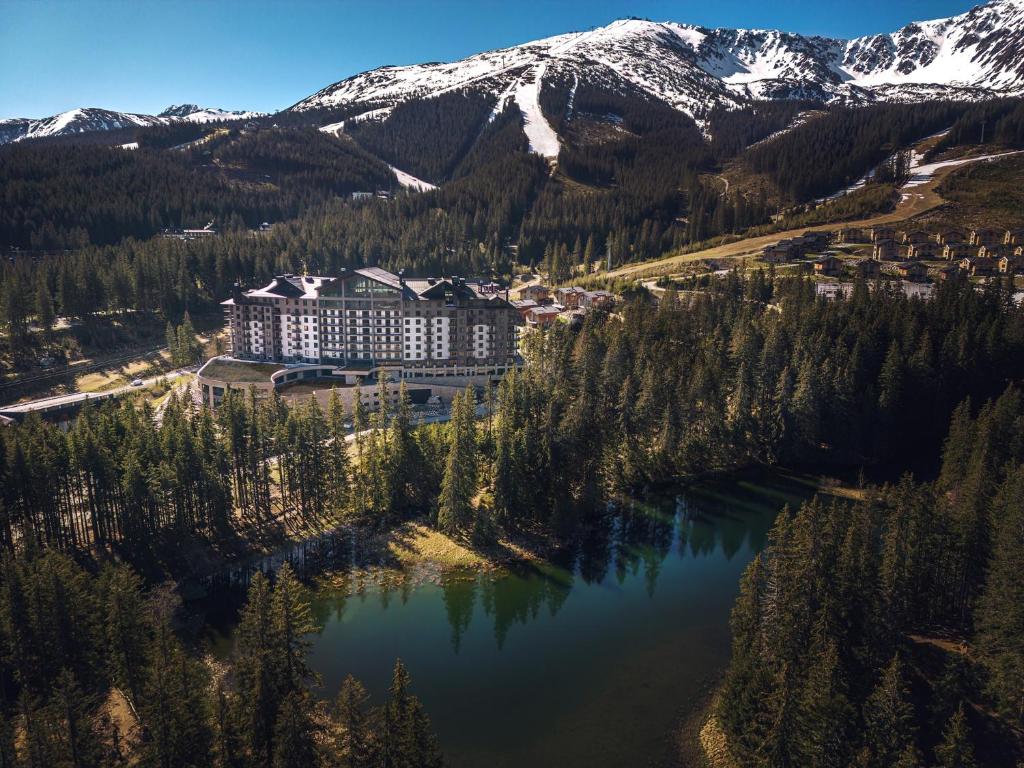 an aerial view of a resort with a lake and mountains at DAMIAN JASNA HOTEL RESORT and RESIDENCES in Demanovska Dolina