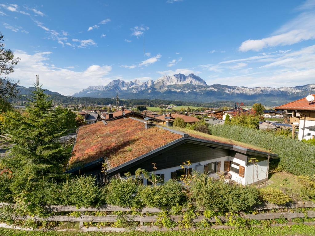 una casa con techo de hierba con montañas al fondo en Chalet Kitzalm, en Oberndorf in Tirol