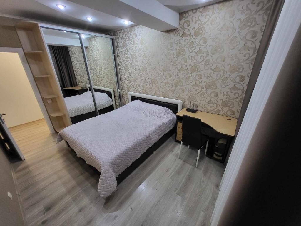 - une petite chambre avec un lit et un miroir dans l'établissement Apartment Buiucani, à Chişinău