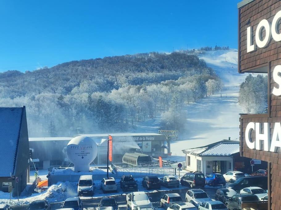 a parking lot with cars parked in front of a building at appartement 6 places station super besse in Besse-et-Saint-Anastaise