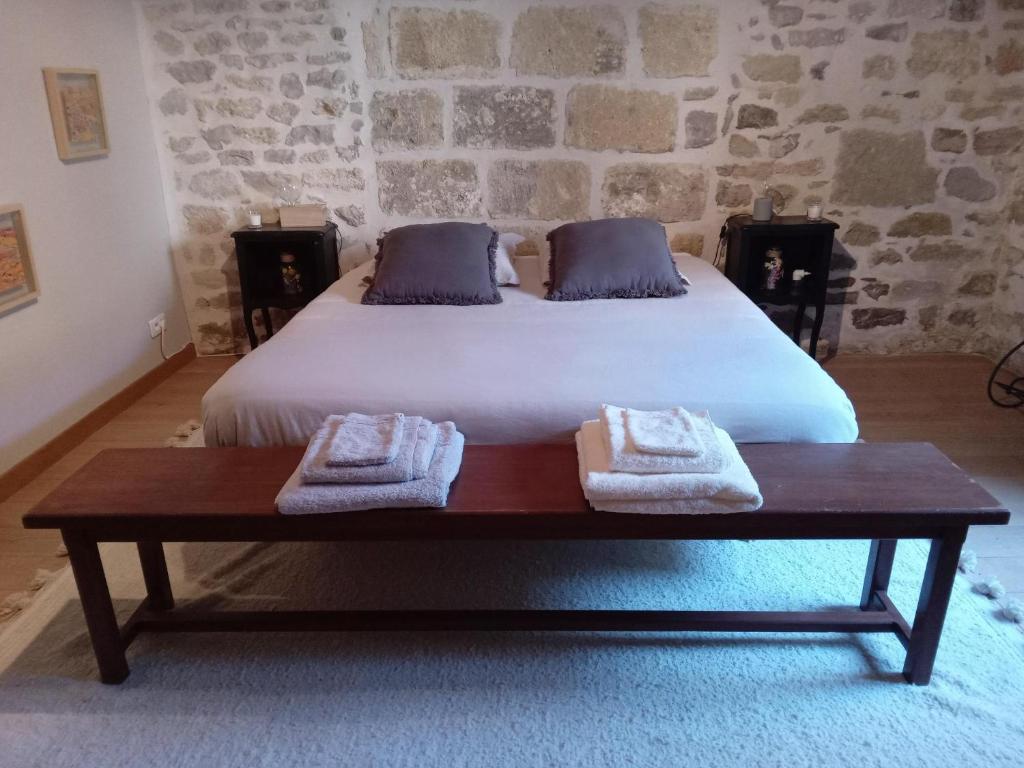 um quarto com uma cama com toalhas num banco em Le clos de l'Olivelle em Gallargues-Le-Montueux