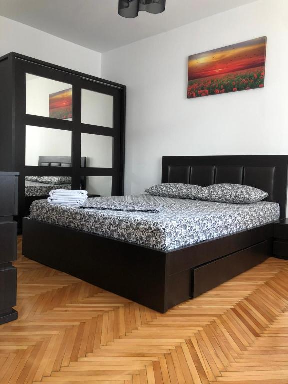 a bed in a room with a picture on the wall at Studio Central Doamnei in Bucharest