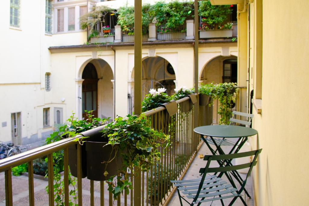 a table and chair on a balcony with plants at Centralissimo, ampio: La passeggiata by HAPPYHOST in Turin