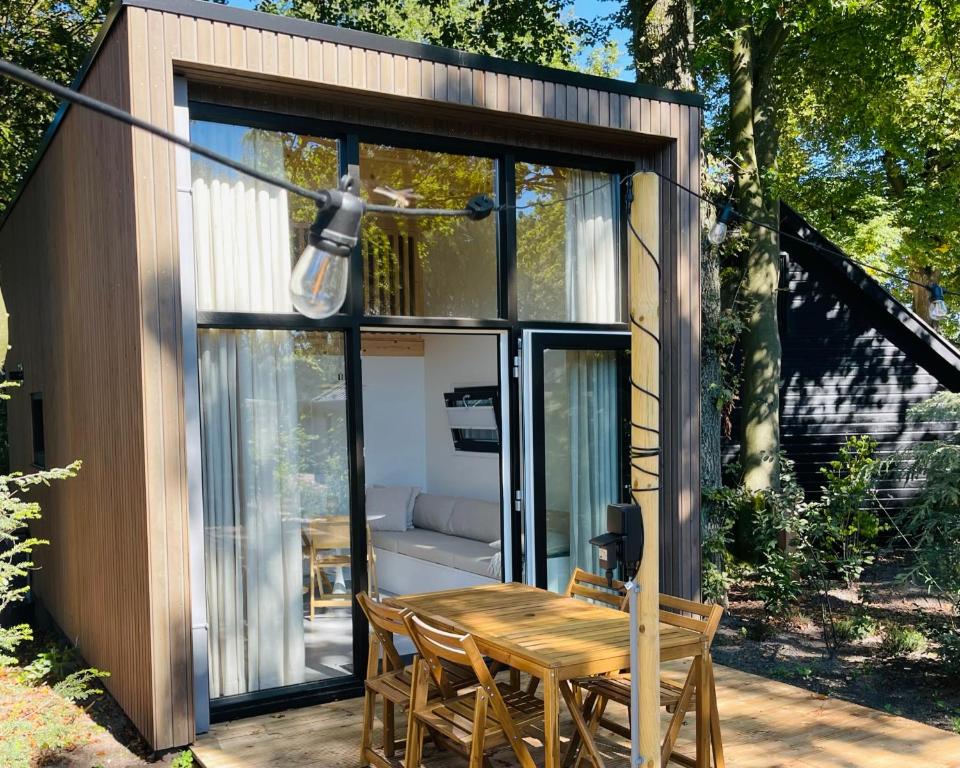 een kleine schuur met een houten tafel en stoelen bij Camping de Vinkenkamp in Lieren