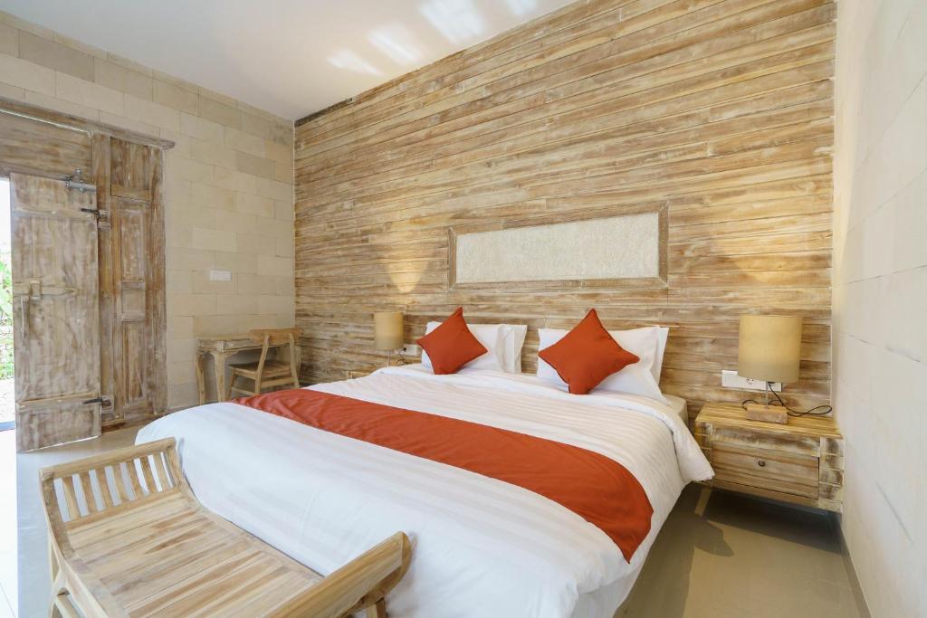 1 dormitorio con 1 cama grande y pared de madera en Agaru Villa Uluwatu by The Lavana, en Uluwatu