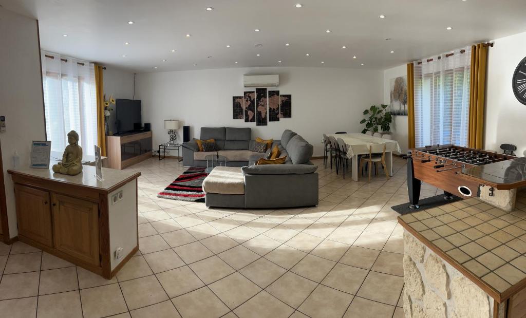ein Wohnzimmer mit einem Sofa und einem Tisch in der Unterkunft La Palmeraie in Saint-Père