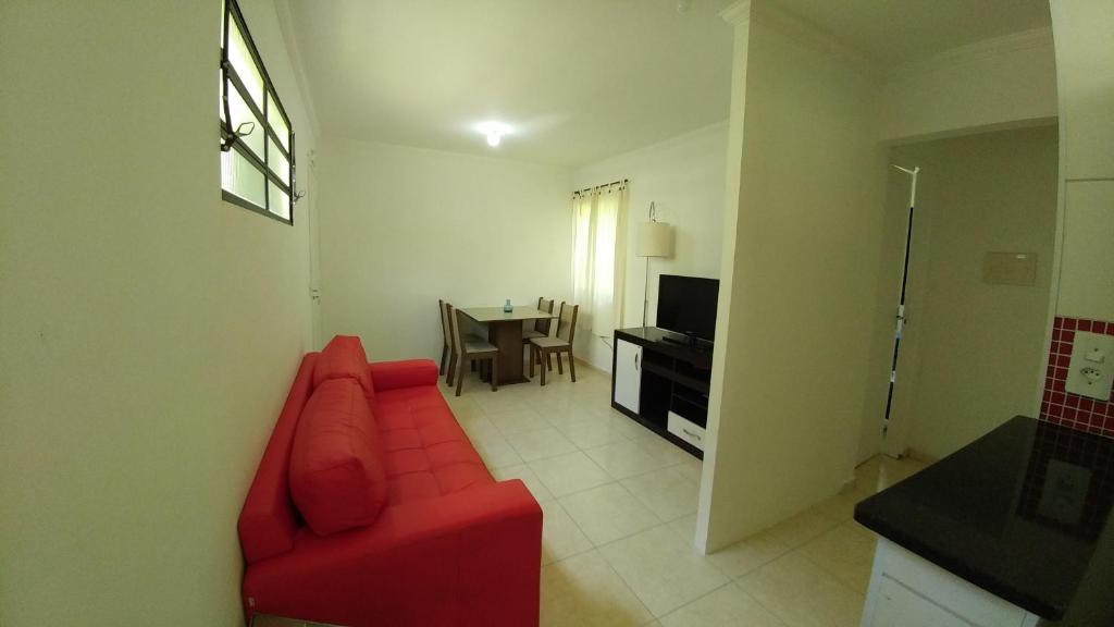 un soggiorno con divano rosso e tavolo di LA01-Bertioga, Próximo ao SESC, Riviera, Vista Linda, Indaiá a Bertioga