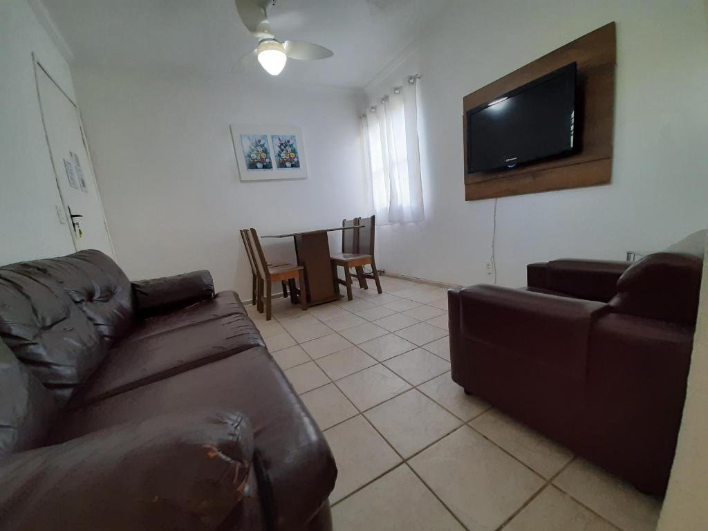 een woonkamer met een bank en een flatscreen-tv bij LA06-Bertioga, Próximo ao SESC, Riviera, Vista Linda, Indaiá in Bertioga