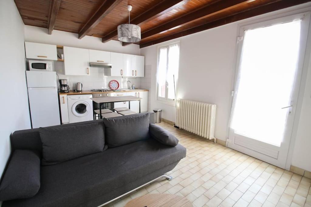 a living room with a couch and a kitchen at Joli T2 rénové / WIFI / Grand parking privé in La Couronne