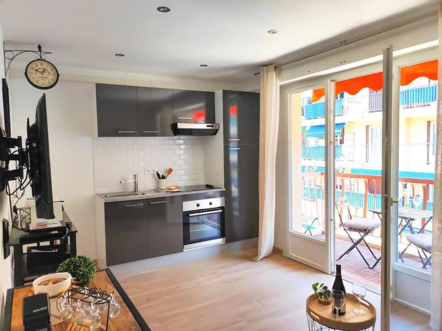 Il comprend un salon avec une cuisine équipée d'une cuisinière et d'un four. dans l'établissement Magnifique appartement -2min gare 5min plage, à Vallauris