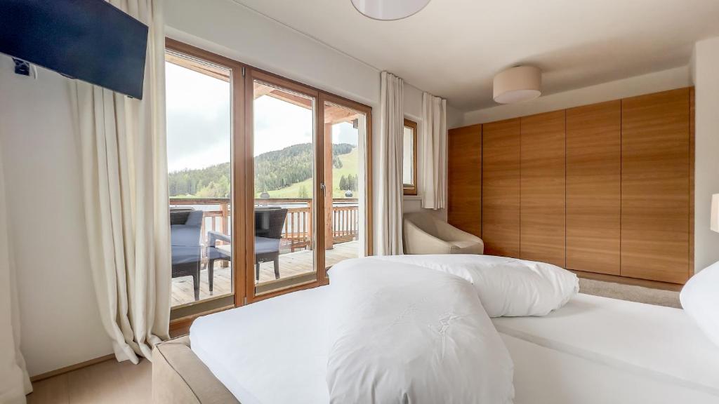 a bedroom with two white beds and a large window at Luxus Chalet - Zentral - Poolblick mit Sauna in Seefeld in Tirol