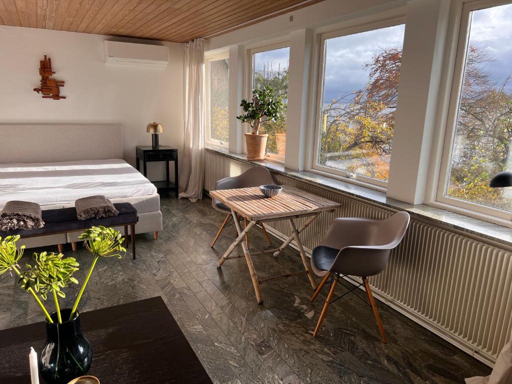 a bedroom with a bed and a table and windows at Sea view nordic design apartment near beach great for couples in Snekkersten