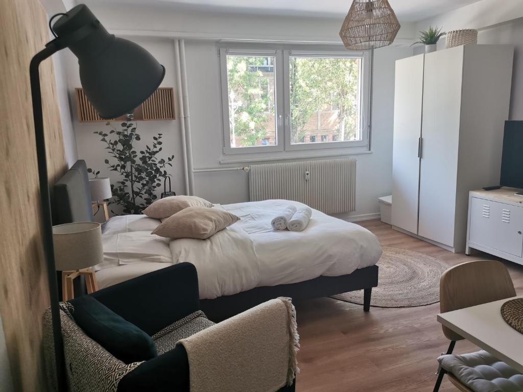 une chambre avec un lit, un bureau et une lampe dans l'établissement Marnesia - Studio avec vue sur les quais, à Strasbourg