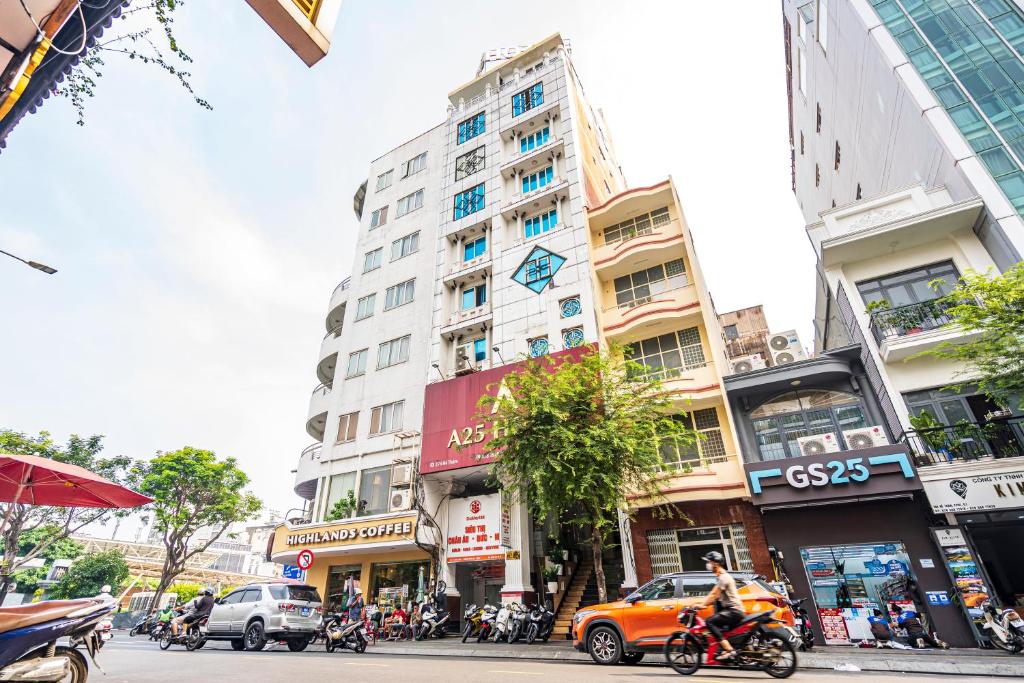 una concurrida calle de la ciudad con edificios altos y gente en motocicleta en A25 Hotel - 274 Đề Thám en Ho Chi Minh