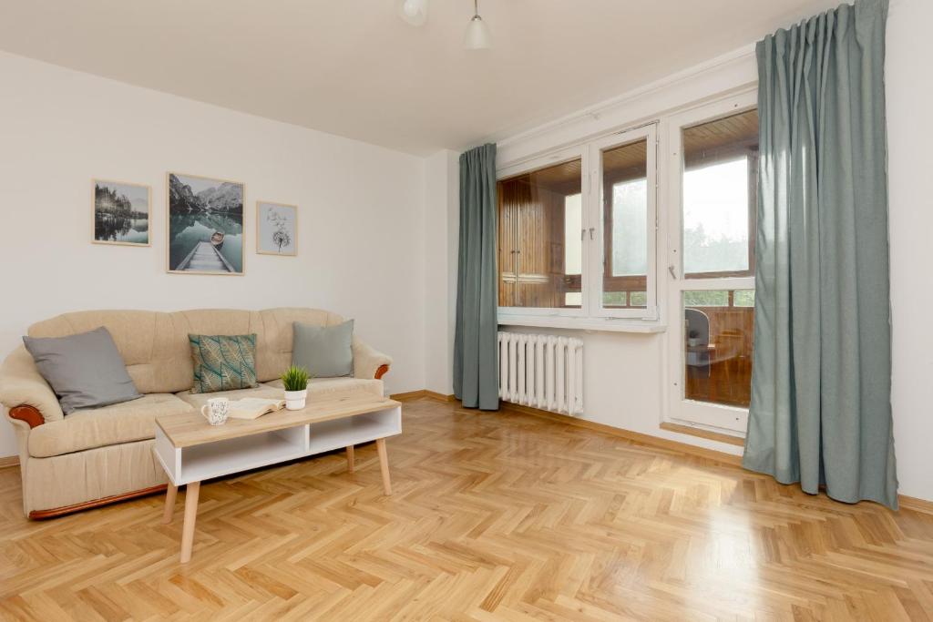 a living room with a couch and a table at Soft Dream Apartment Warsaw Bemowo by Renters in Warsaw