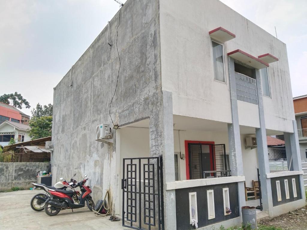 una motocicleta estacionada frente a un edificio en MyKost Palupuh Valley Syariah, en Bogor
