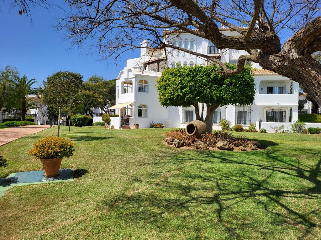 a large white house with a tree in the yard at Elviria del Sol in Marbella