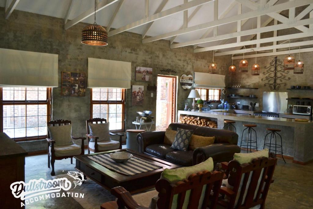 a living room with a couch and a table at Whispering Pines in Dullstroom