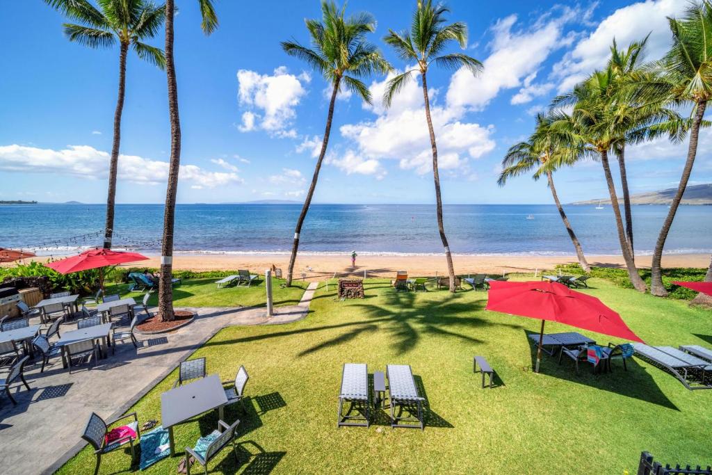 a beach with chairs and umbrellas and the ocean at Nani Kai Hale A209 in Kihei