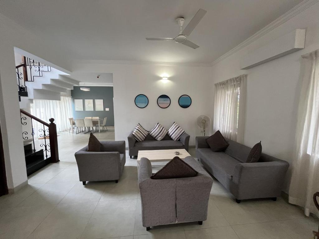 a living room with two couches and a table at Mansions by Pinto Rosario in Bastora