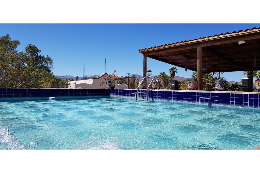 a large swimming pool with a pergola at Collection O Posada De Las Flores Loreto in Loreto