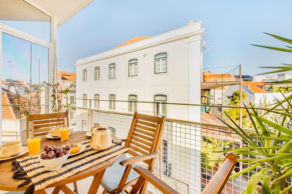 リスボンにあるPríncipe Real Sunny Apartmentの建物の景色を望むバルコニー(テーブル、椅子付)