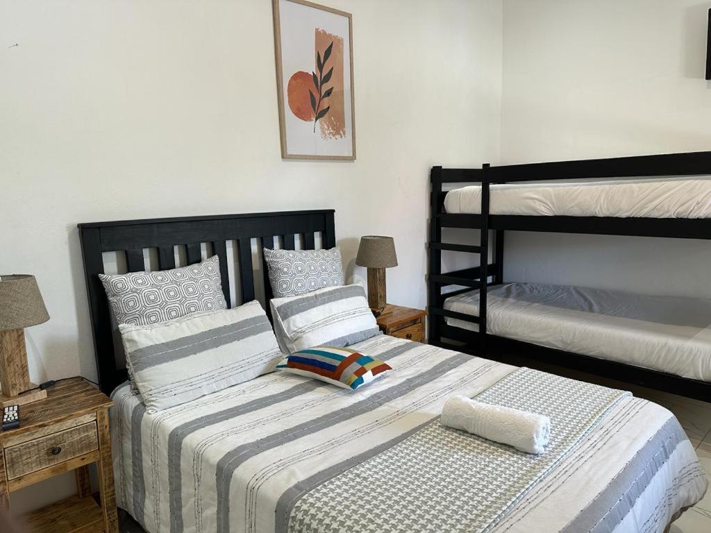 a bedroom with two twin beds and two bunk beds at MELJAA STAR Guesthouse in Cape Town