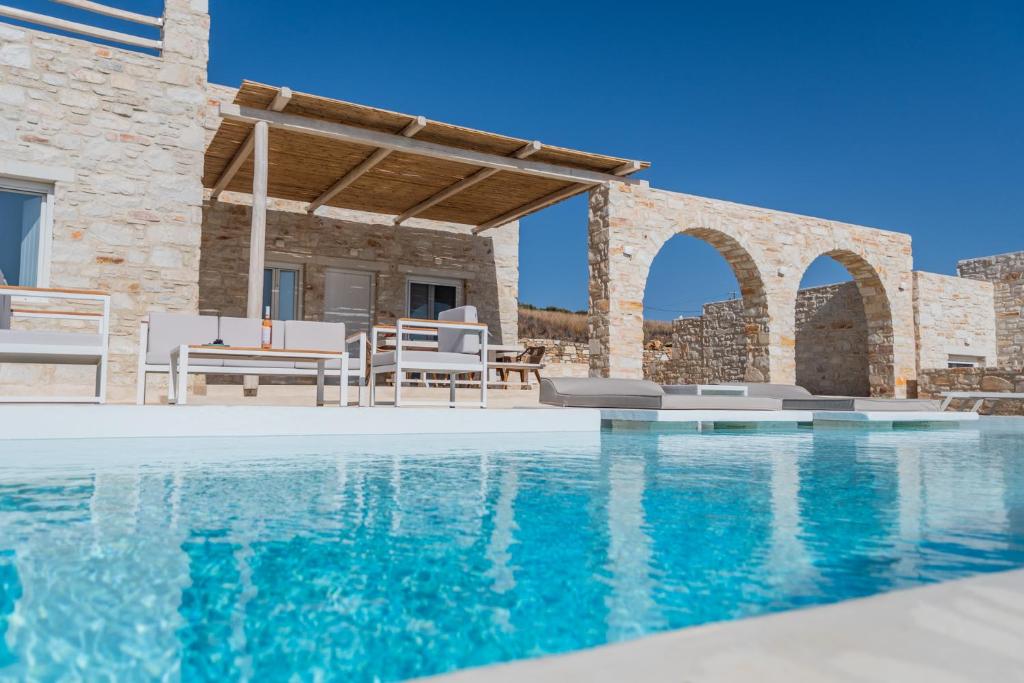 a villa with a swimming pool and a patio at Aegean Feelings in Piso Livadi