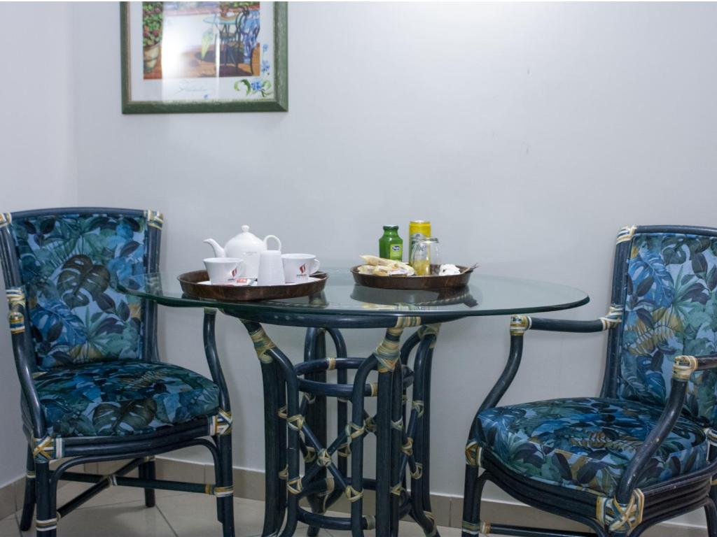 un tavolo con due sedie e un tavolo con bevande di Hotel Serena a Napoli