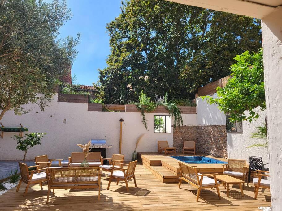 une terrasse avec des chaises, une table et une piscine dans l'établissement Maison classée 5 étoiles à 3km de la mer - Wine and Kite, à Torreilles