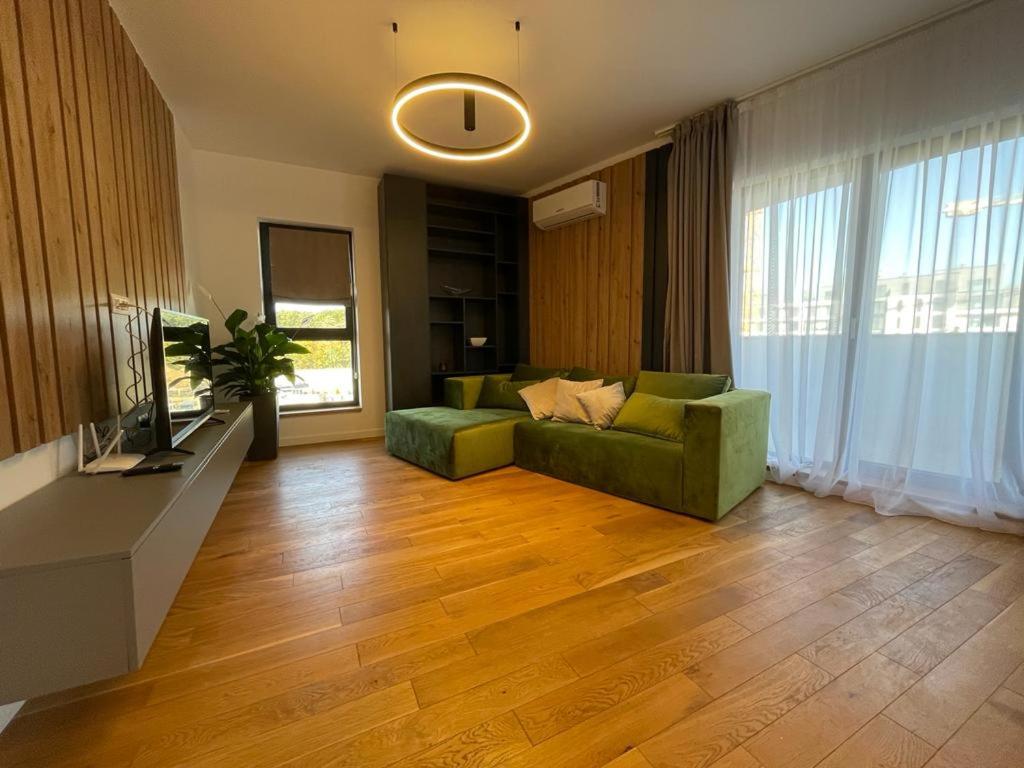 a living room with a green couch and a television at UpNorth Home in Bucharest