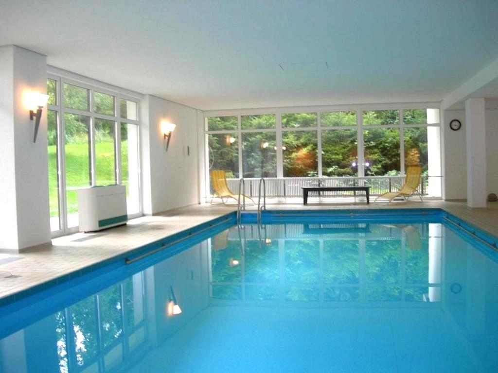 una gran piscina de agua azul en una casa en Atelier Probst Schönwald, en Aufʼm Bühl