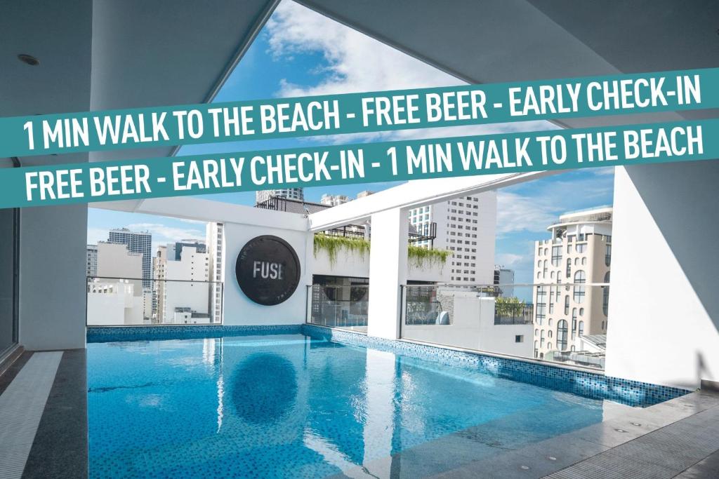 a swimming pool in a building with the words mile walk to the beach free beer at FUSE Nha Trang in Nha Trang