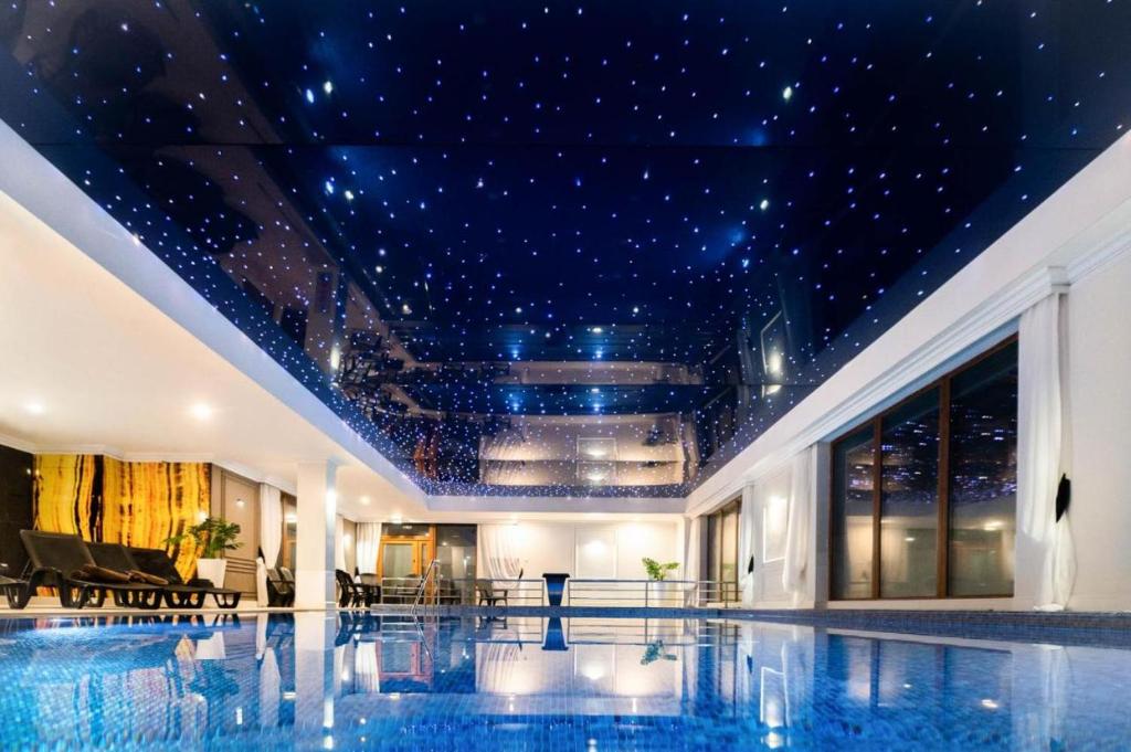 - une piscine dans un bâtiment doté d'un plafond étoilé dans l'établissement Ultra All Inclusive Apartament w Amber Park Spa, à Niechorze