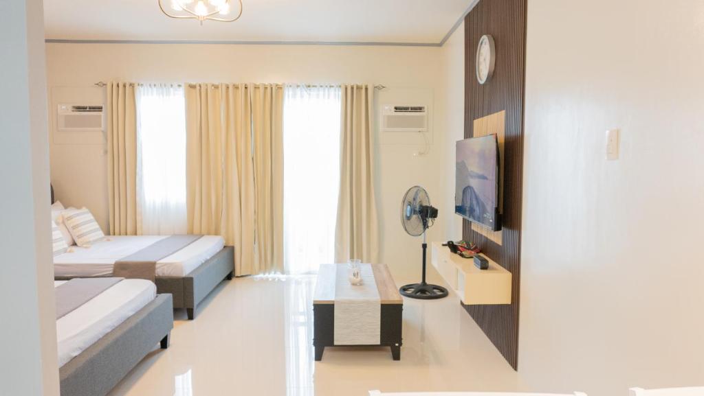 um quarto com uma cama, uma mesa e uma televisão em Palawan Twin-Bed Paradise with a Balcony plus FREE Pool, Gym & Parking-7Kunzite em Puerto Princesa