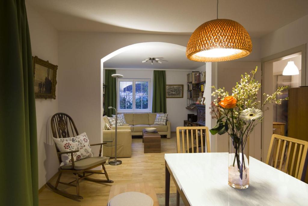ein Wohnzimmer mit einer Blumenvase auf dem Tisch in der Unterkunft Dreimädelshaus in Uhldingen-Mühlhofen