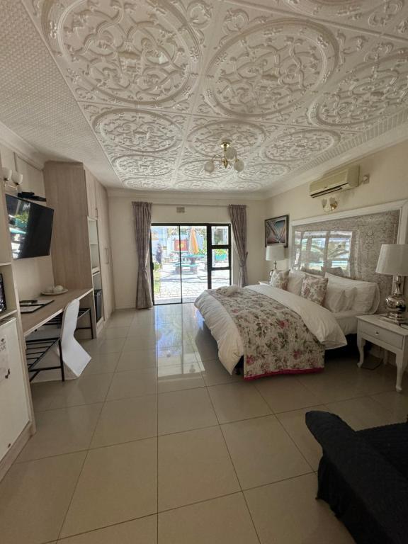 1 dormitorio con cama y techo artesonado en Blue Diamond Lodge & Spa, en Springbok