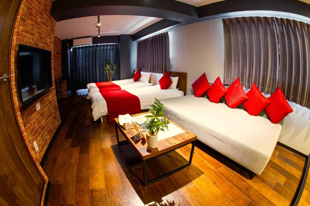 Habitación de hotel con 2 camas y TV en e-stay namba, en Osaka