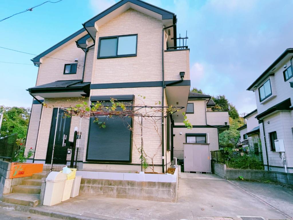 una gran casa blanca con garaje en 美山小屋-临近东京夏日乐园，高尾山，相模湖游乐园, en Hachioji