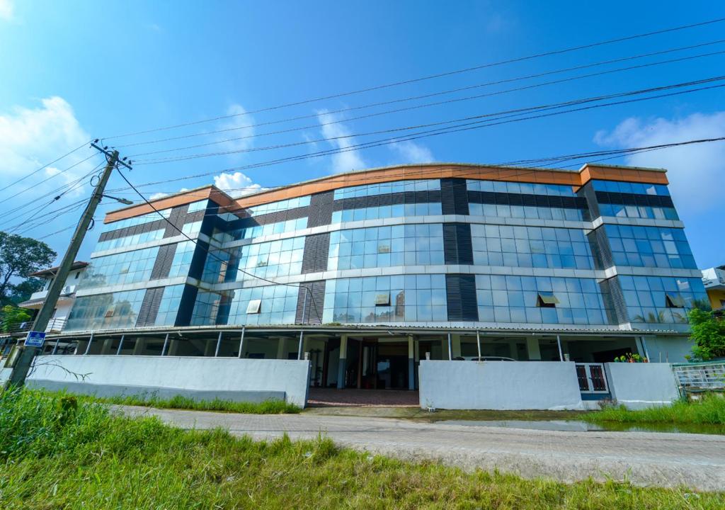 a tall building with a lot of windows at Prime Casadel Rooms And Apartments in Kakkanad