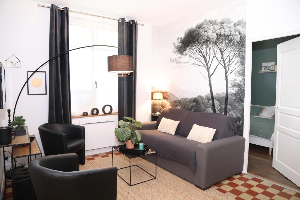 a living room with a couch and a table at Suite Garden by La Boîte En Plus in Senlis